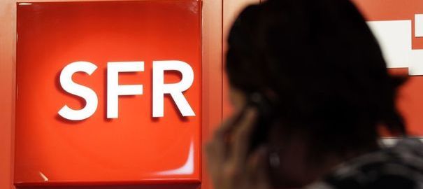 90062_a-customer-uses-a-mobile-phone-as-he-stands-next-to-a-logo-of-french-mobile-phone-operator-sfr-in-a-shop-in-nice
