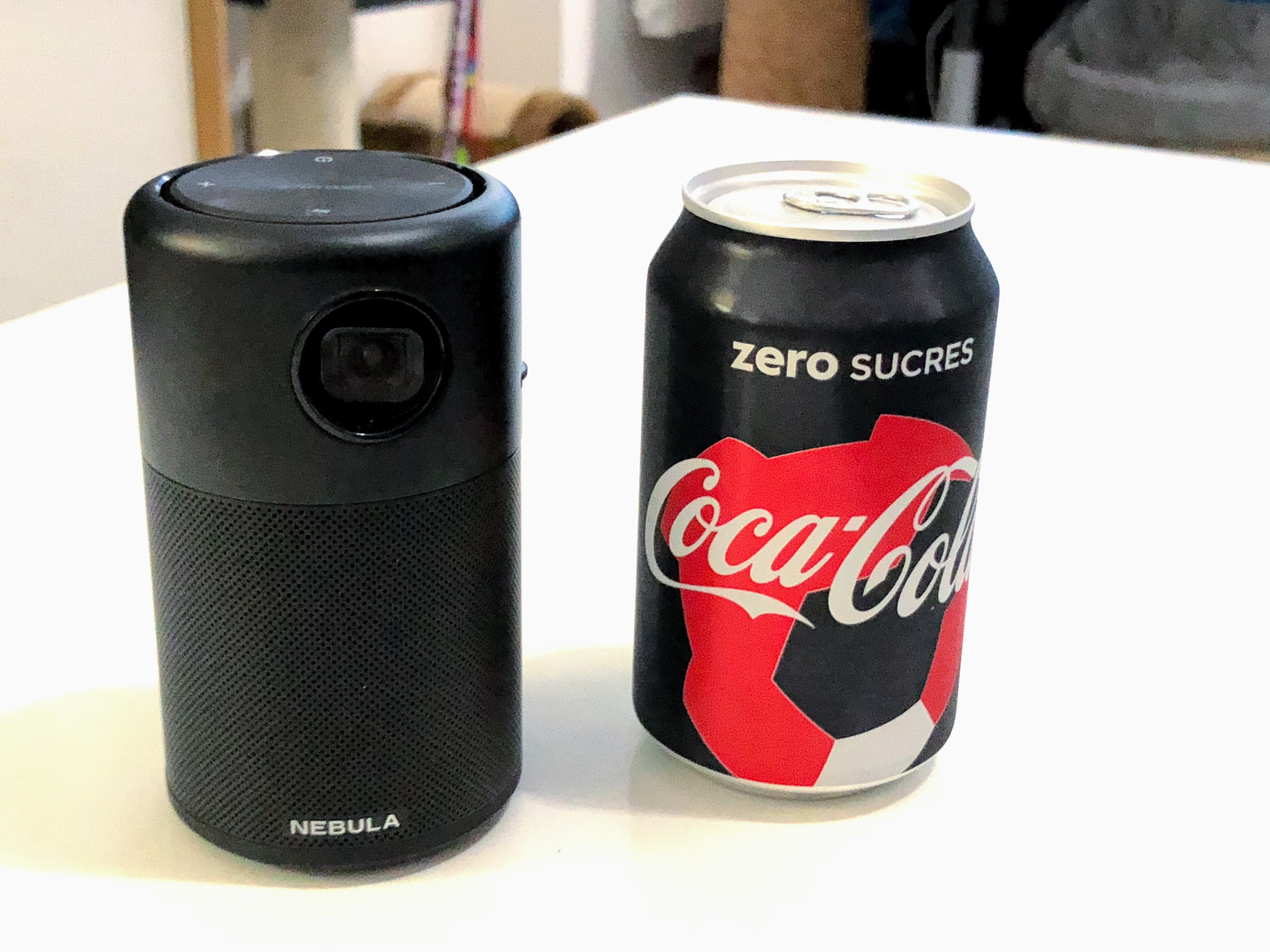 Le Nebula Capsule à côté d'une canette de Coca Cola Zero.