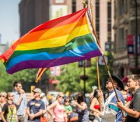 Marchers in the 2013 Twin Cities Pride parade carry rainbow flags as spectators watch along Hennepin Avenue in Minneapolis, Minnesota.