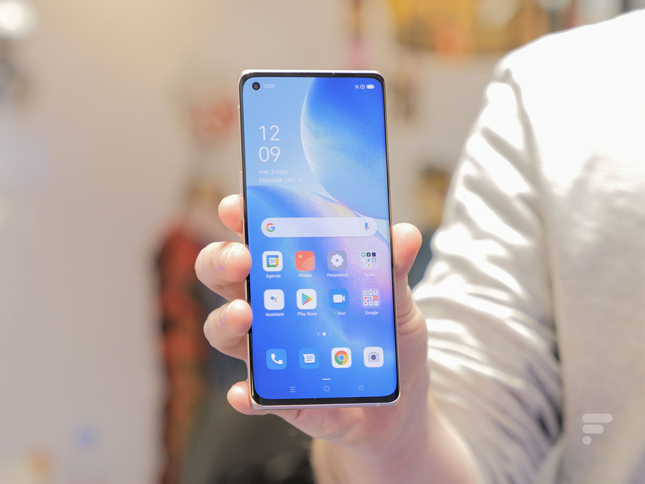 Le Oppo Find X3 Neo tenu dans la main de quelqu'un, avec l'écran allumé