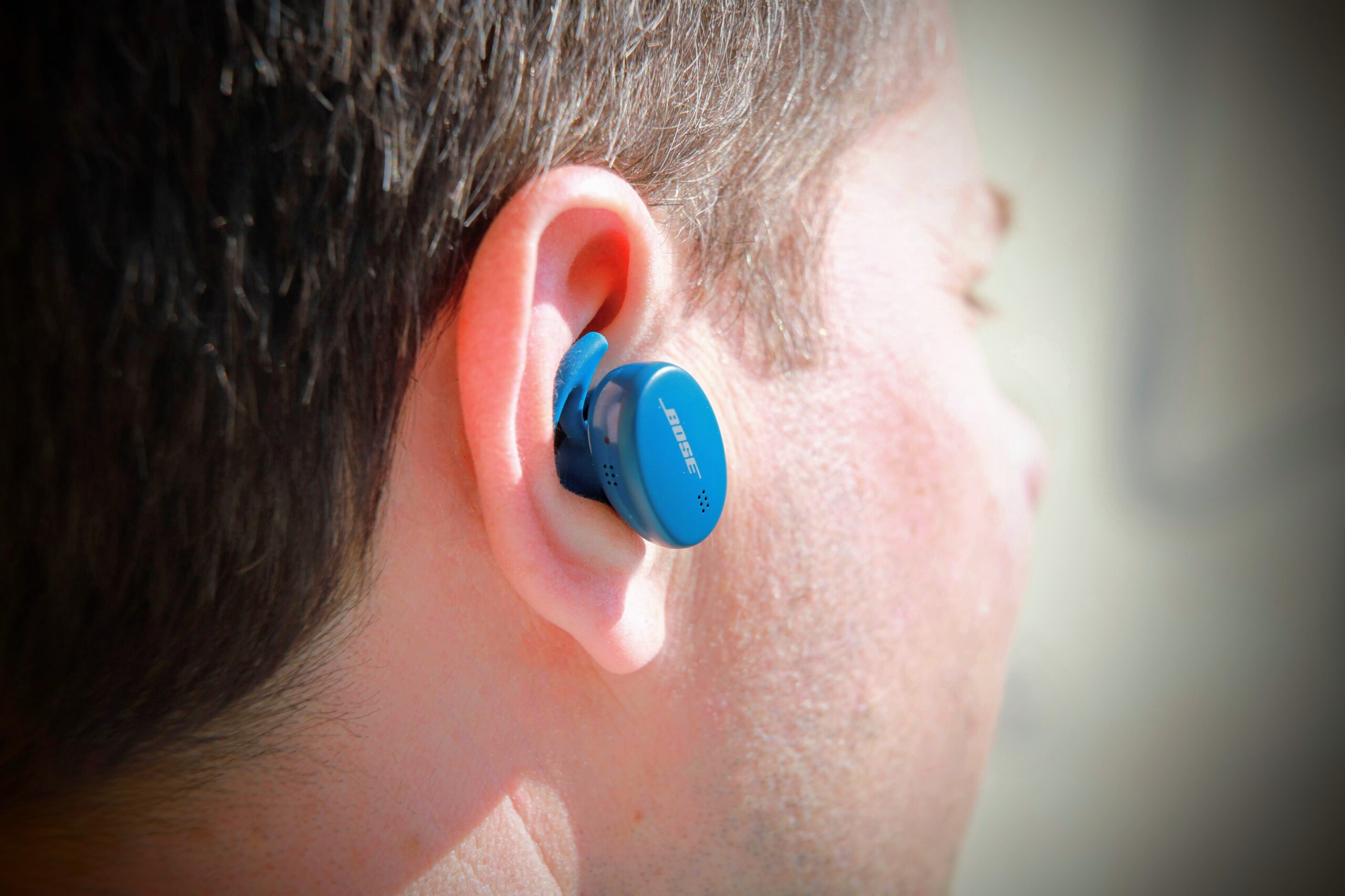 Ecouteurs Bose Sport Earbuds devant leur boîtier de charge
