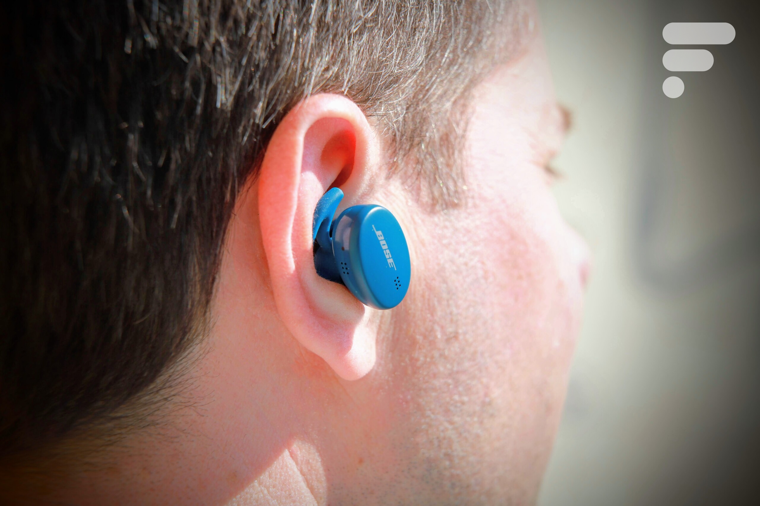 Ecouteurs Bose Sport Earbuds devant leur boîtier de charge