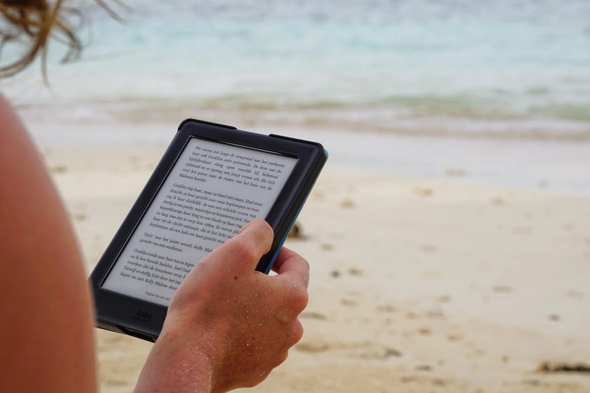 Personne lisant sur sa liseuse Amazon Kindle à la plage