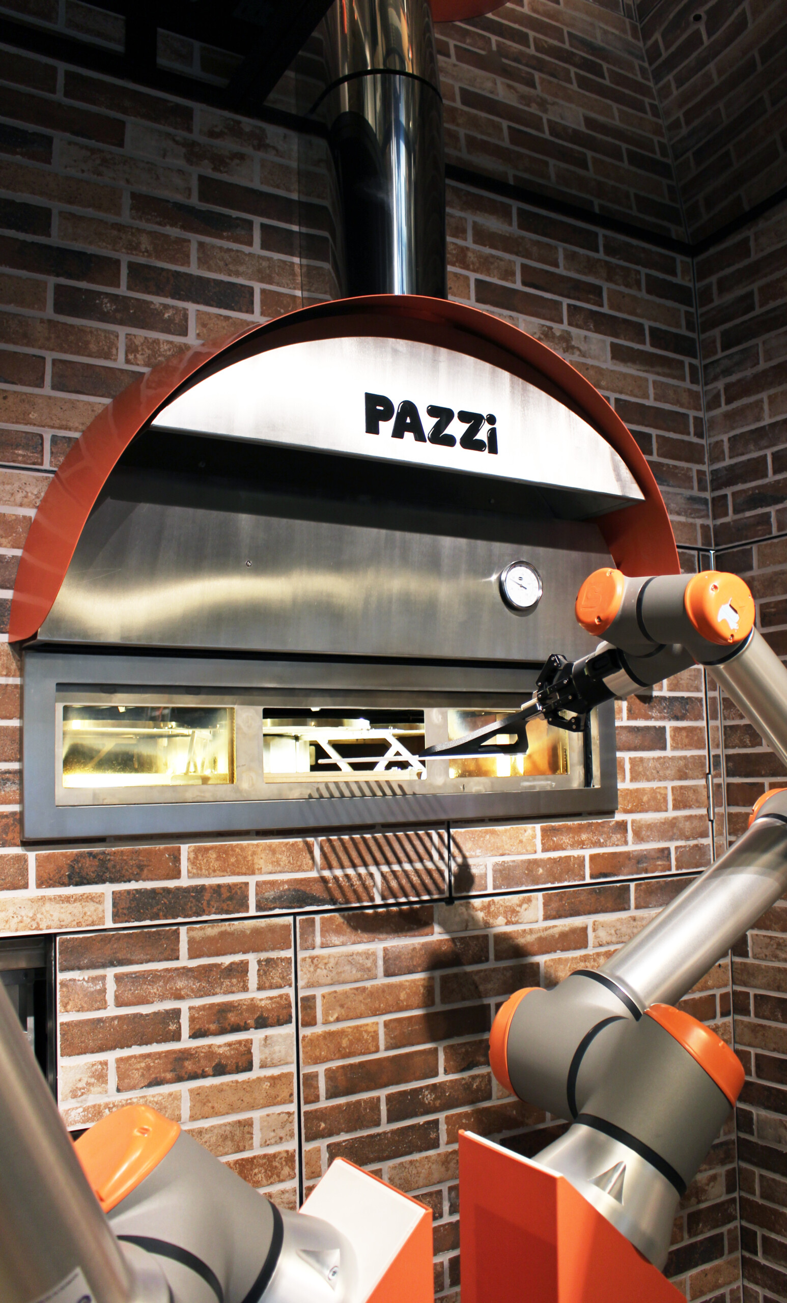 Le robot sort la pizza du four // Source : Pazzi