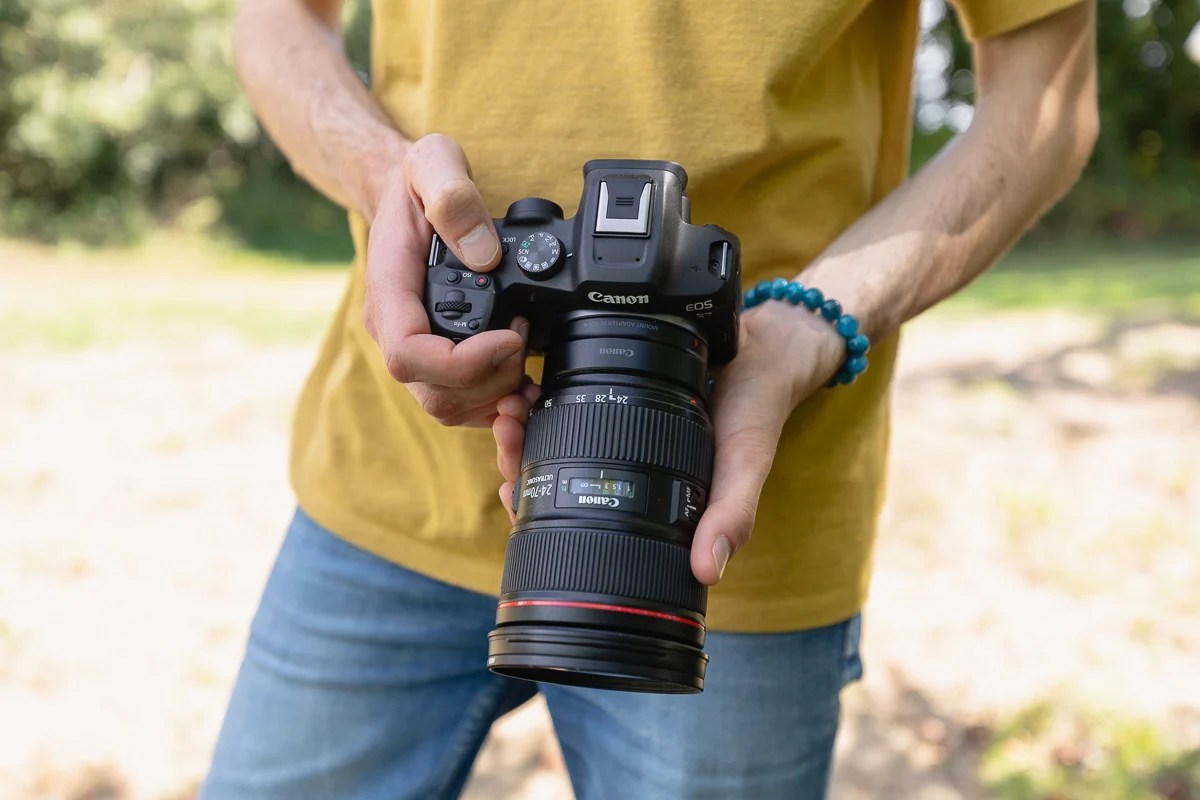 appareil photo et objectif en main