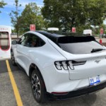 A Mustang Mach-E at at Tesla charging station.
