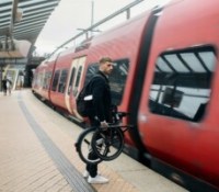 Un vélo électrique dans une gare, près d'un train. // Source : Honbike