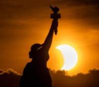 Photo d'éclipse avec la statue de la liberté au premier plan // Source : Anthony Quintano