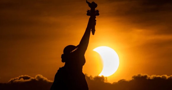 Photo d'éclipse avec la statue de la liberté au premier plan // Source : Anthony Quintano Photo d'éclipse avec la statue de la liberté au premier plan // Source : Anthony Quintano