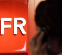 90062_a-customer-uses-a-mobile-phone-as-he-stands-next-to-a-logo-of-french-mobile-phone-operator-sfr-in-a-shop-in-nice