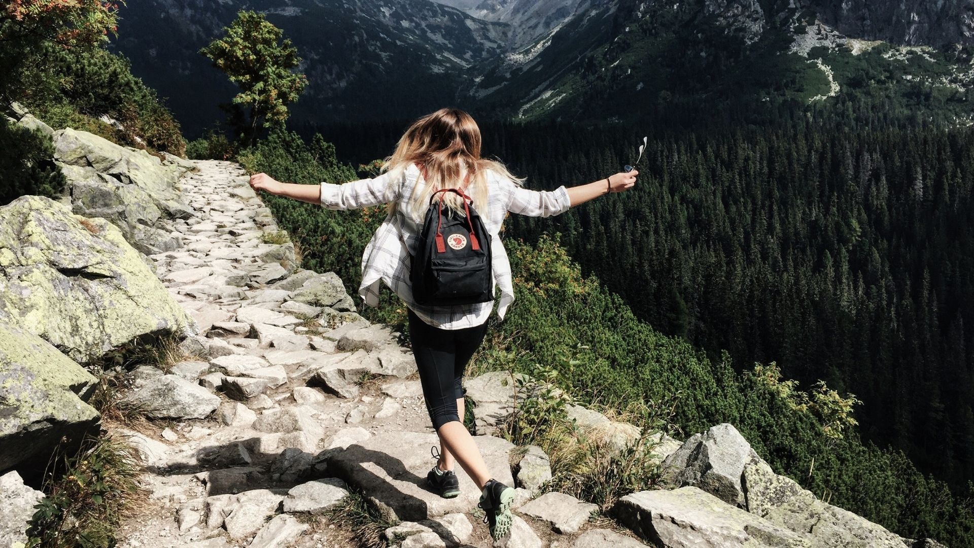 femme sur un sentier avec un sac à dos