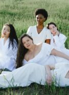 Un groupe de femmes habillées en blanc allongées dans l'herbe (photo prétexte de banque d'image)