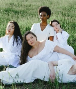 Un groupe de femmes habillées en blanc allongées dans l'herbe (photo prétexte de banque d'image)