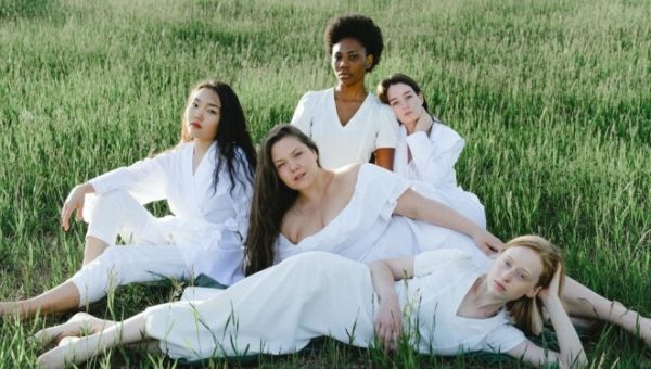 Un groupe de femmes habillées en blanc allongées dans l'herbe (photo prétexte de banque d'image)