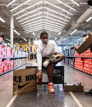 Une femme en train d'essayer des baskets dans une boutique Nike