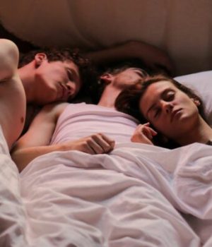trois personnes dans un lit