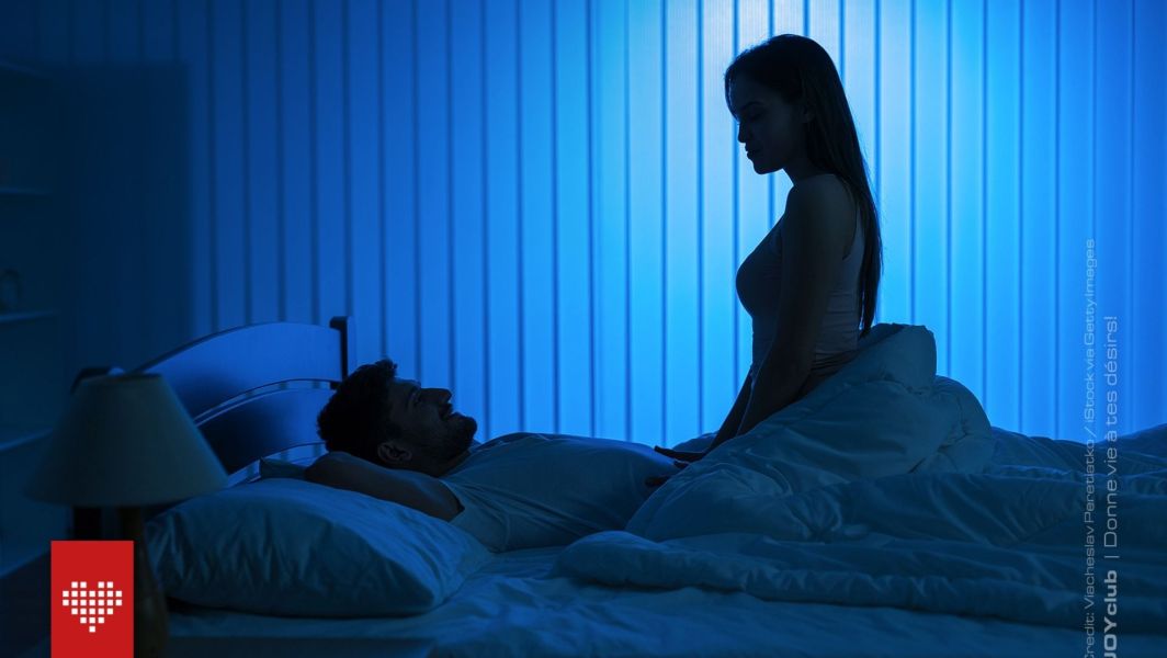 un homme et une femme dans une chambre à la lumière tamisée