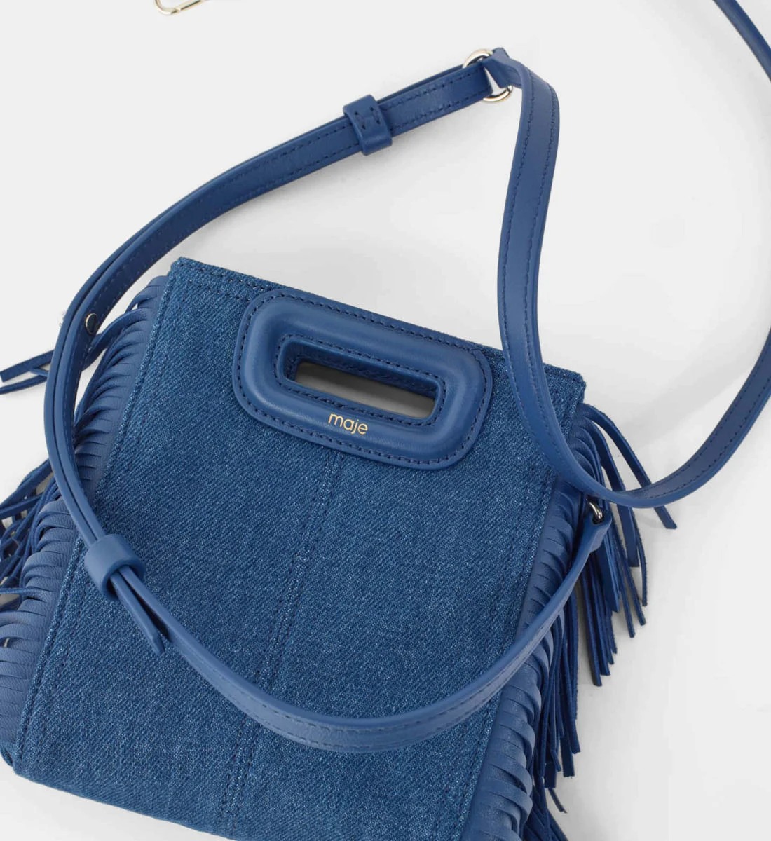 Sac en denim de coton mélangé, franges en cuir de mouton, et bandoulière épaule amovible en cuir, Maje, 156€ au lieu de 195€.