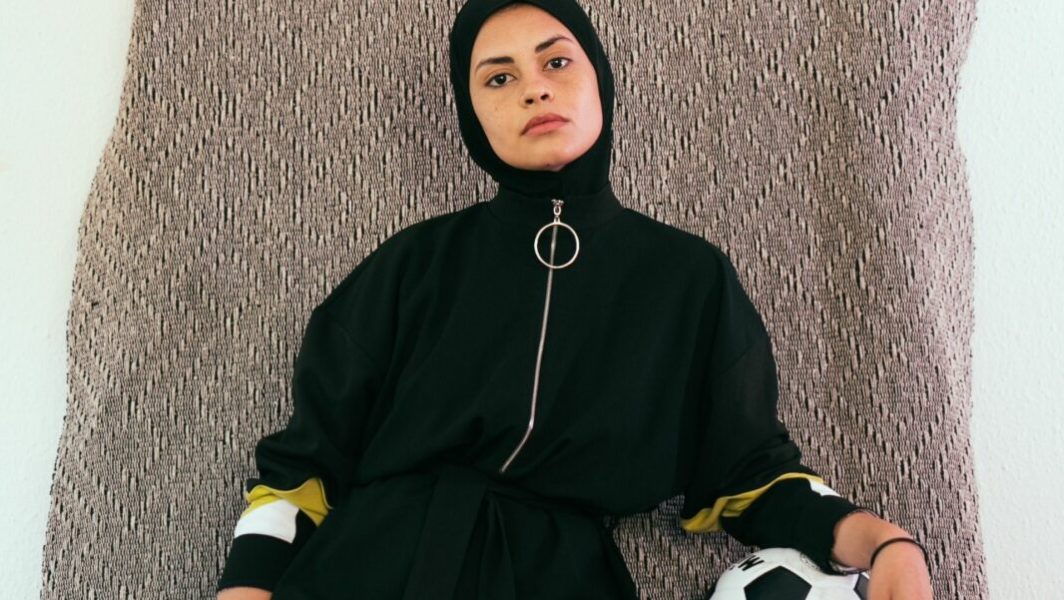 femme portant un hijab de sport avec un ballon de foot