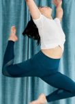 Femme sautant dans les airs dans un studio de yoga