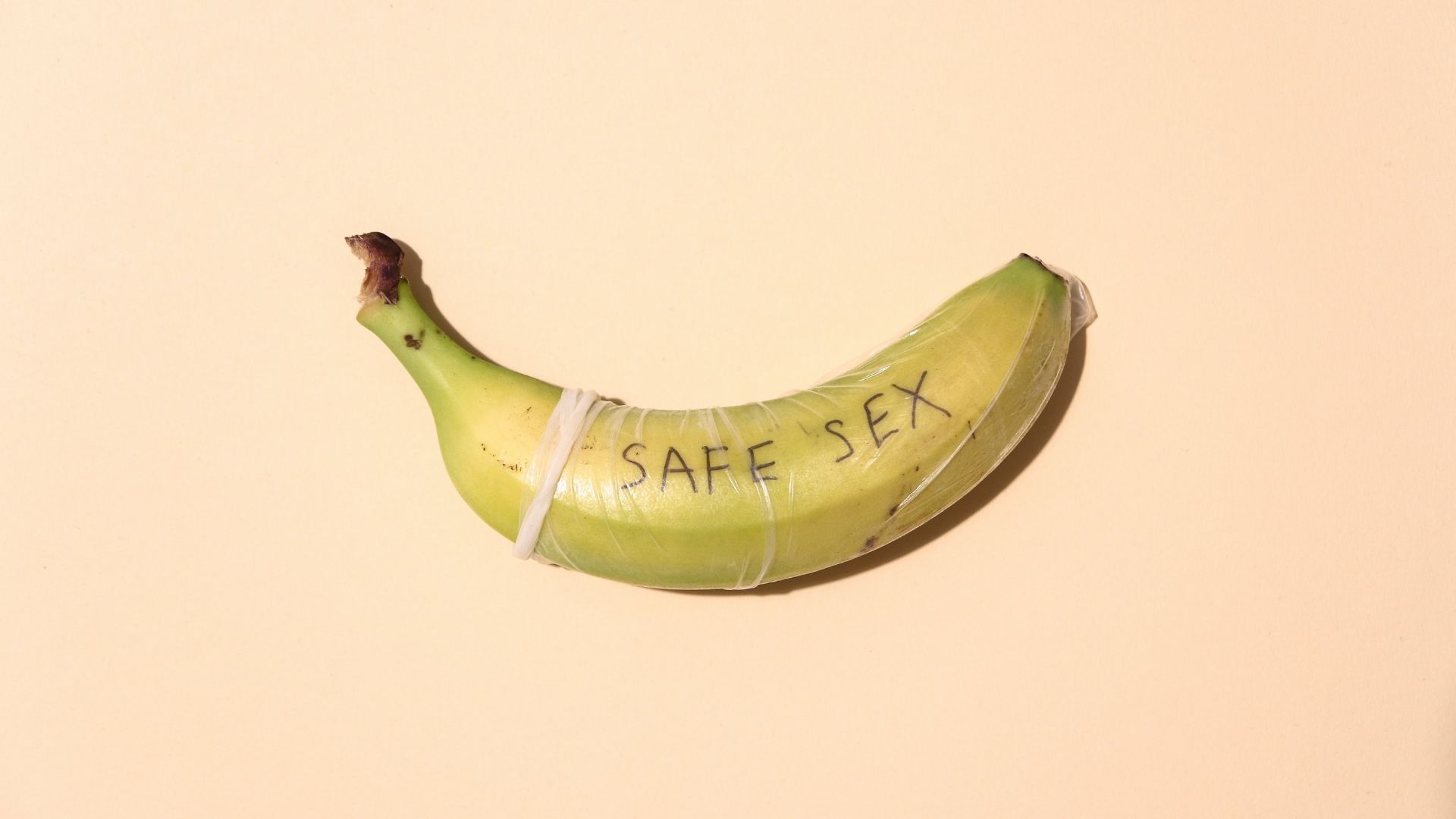 Banane entourée d'un préservatif masculin avec inscription "safe sex"