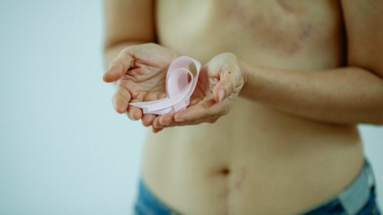 Personne tenant des rubans roses, symboles de la lutte contre le cancer du sein Personne tenant des rubans roses, symboles de la lutte contre le cancer du sein