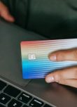 Personne surfant sur internet, une carte de crédit Mastercard à la main