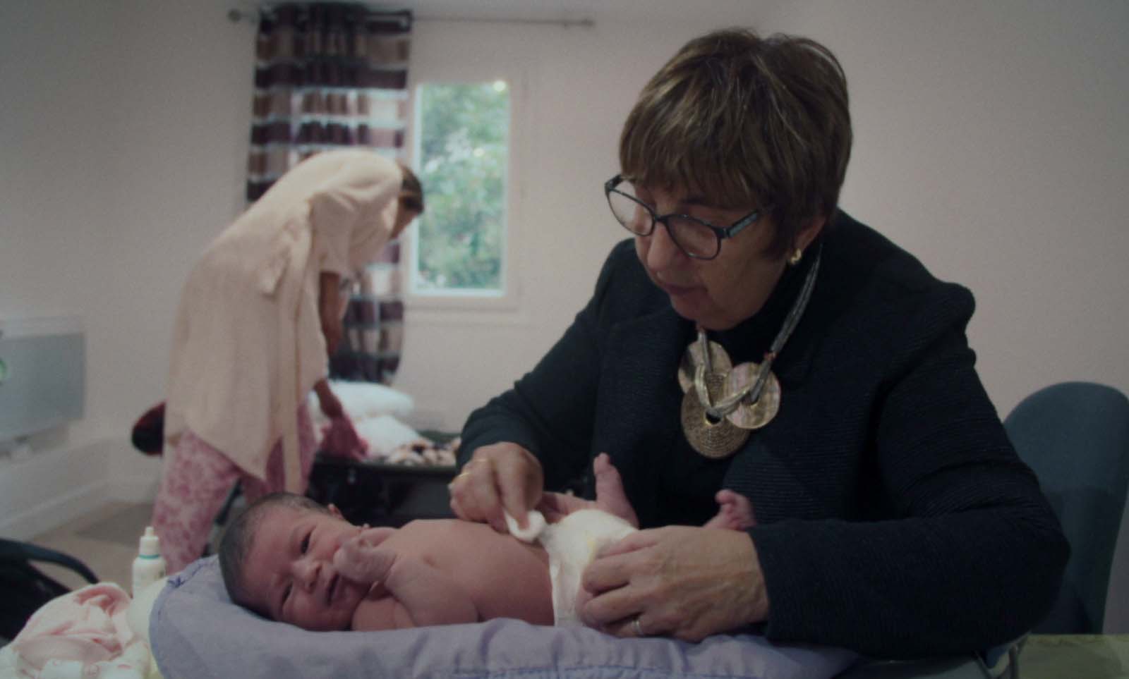 Chantal Birman, une sage-femme âgée, s'occupe d'un bébé dont elle change la couche. Chantal Birman, une sage-femme âgée, s'occupe d'un bébé dont elle change la couche.