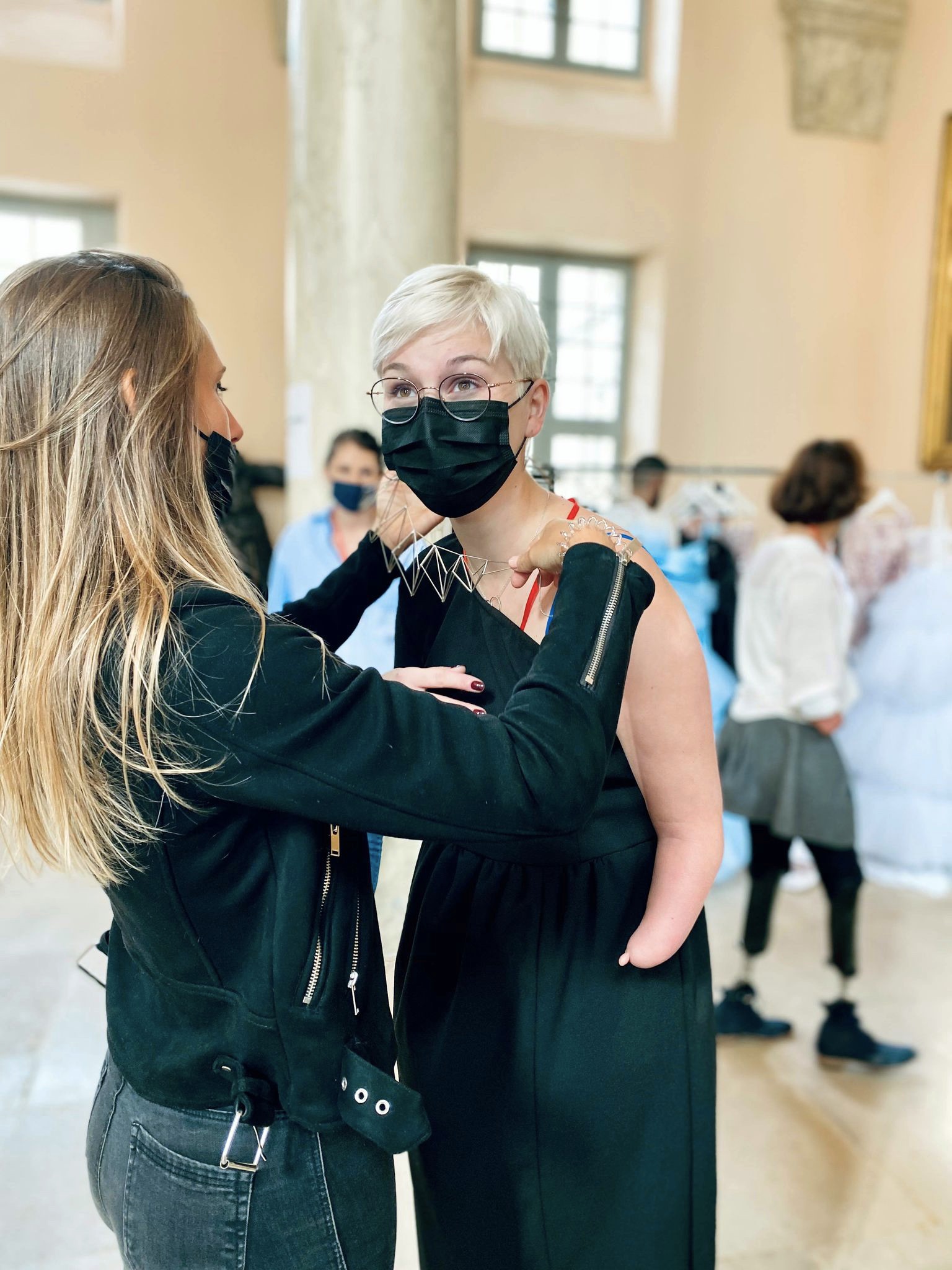 Charlotte, née sans avant-bras gauche, se penche pour qu'on lui enfile son plastron.