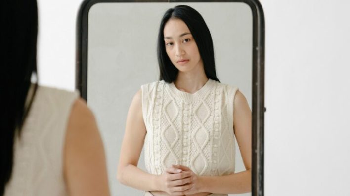 Femme debout devant un miroir