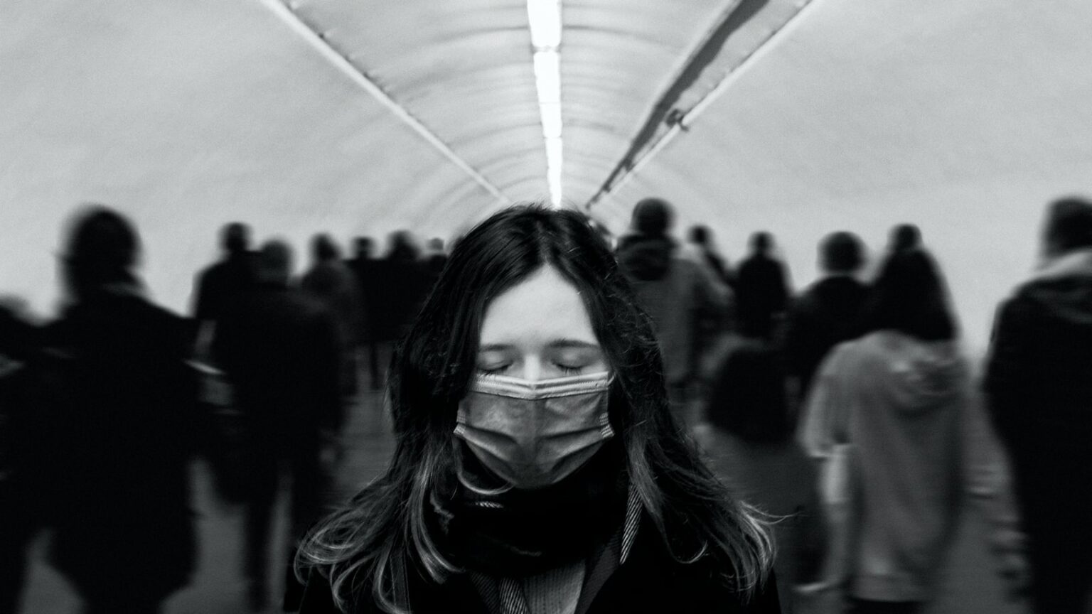 Une femme porte un masque chirurgical dans les couloirs du métro. Une femme porte un masque chirurgical dans les couloirs du métro.
