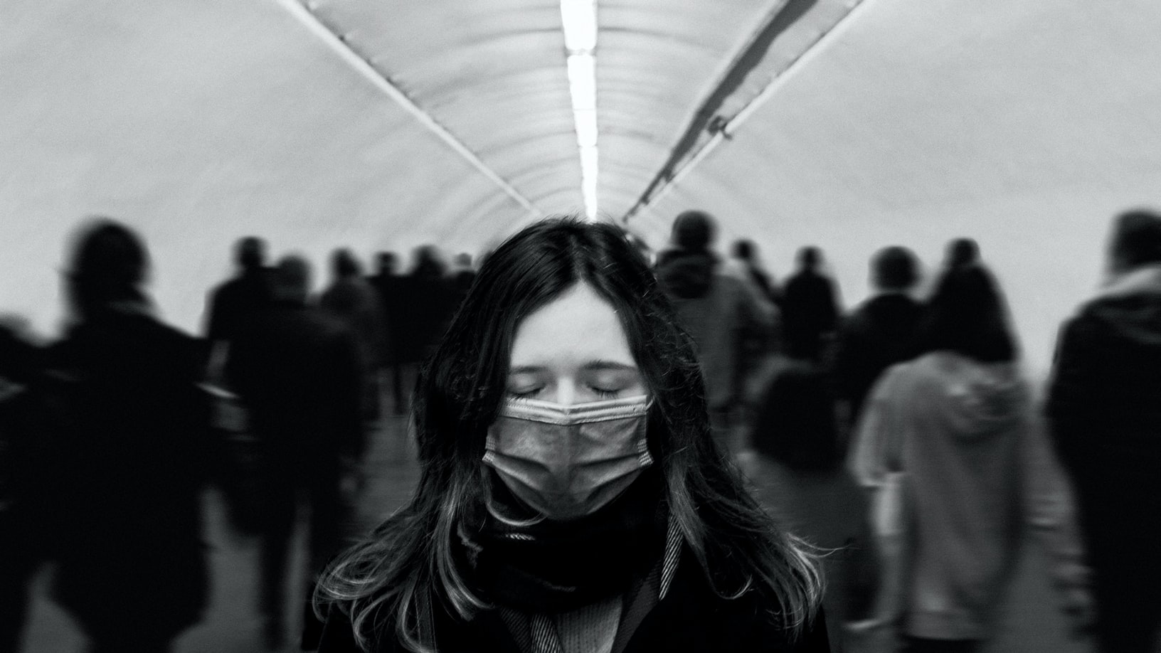Une femme porte un masque chirurgical dans les couloirs du métro.