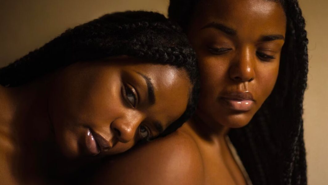 Deux femmes noires, l'une pose sa tête sur l'épaule de l'autre.