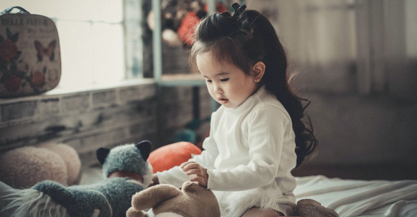 Une petite fille jouant avec des peluches.
