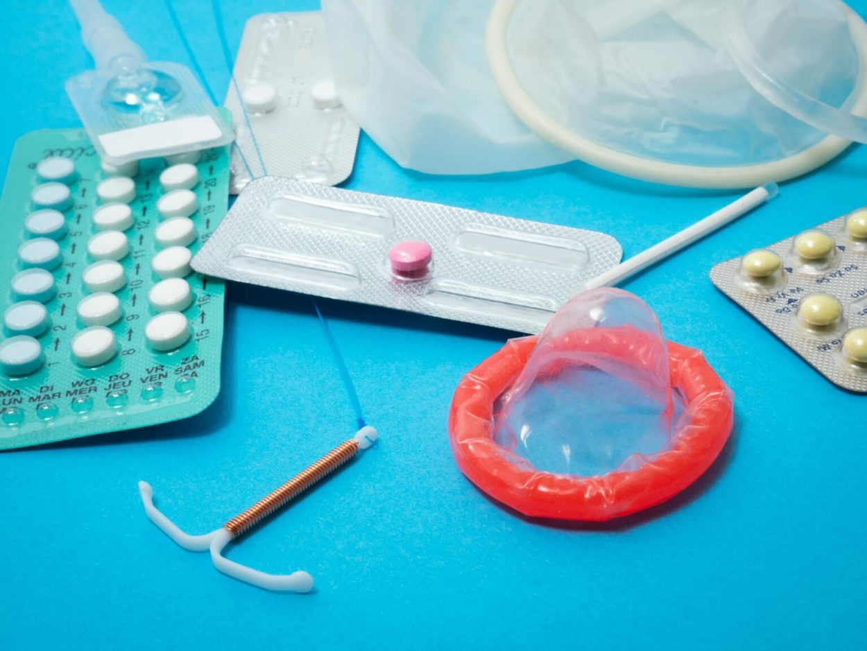 Plusieurs moyens de contraception répartis sur une table.