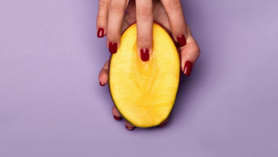 Main touchant une mangue