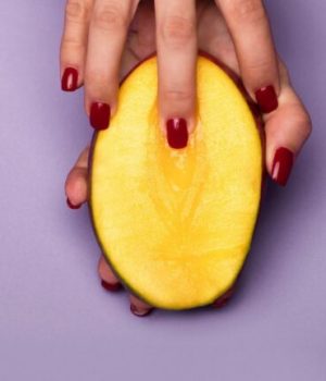 Main touchant une mangue Main touchant une mangue