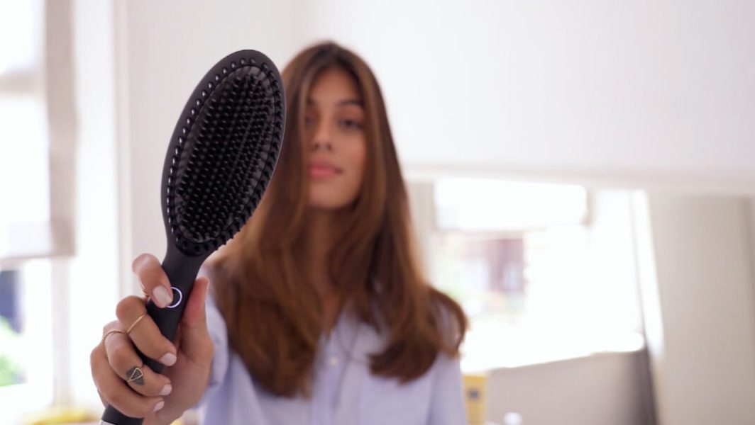 Femme avec la brosse lissante GHD Glide