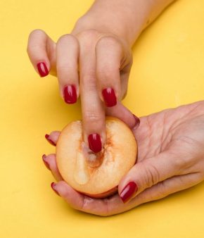 Femme mimant la masturbation sur un fruit