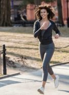 Femme courant tout en souriant dans un parc