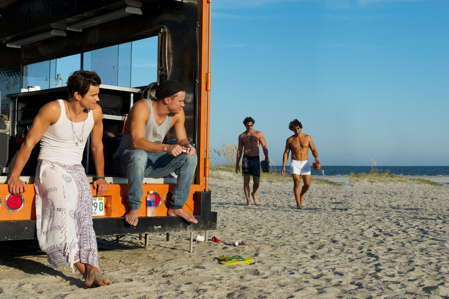 Quatre personnages de Magic Mike XXL sur une plage Quatre personnages de Magic Mike XXL sur une plage
