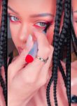 la chanteuse Rihanna appliquant de l'eye-liner rouge