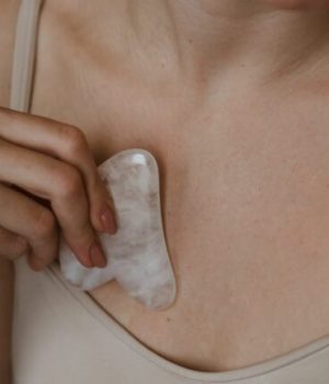 Femme se frottant sa poitrine avec un objet froid