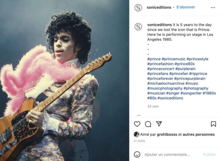 Prince sur scène avec costume et boa rose