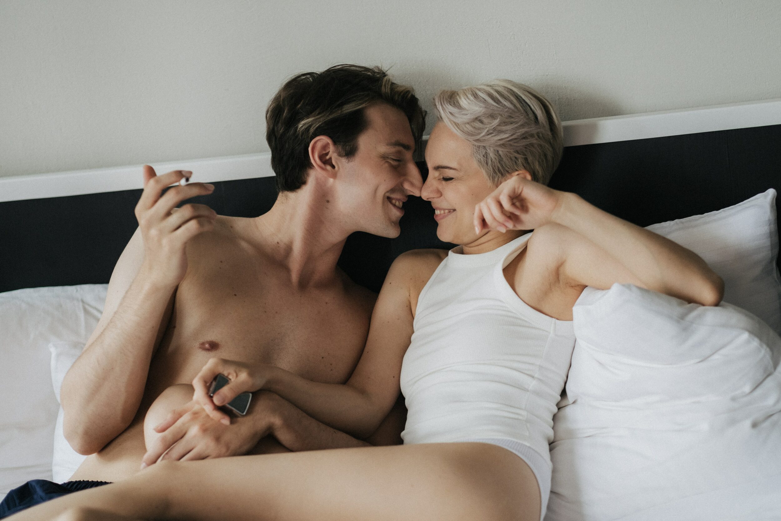 Couple souriant dans un lit.