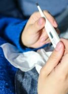 Personne malade avec un thermomètre dans les mains