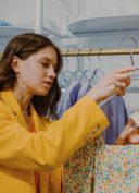 Une femme en train de regarder une étiquette de vêtement dans une boutique de mode