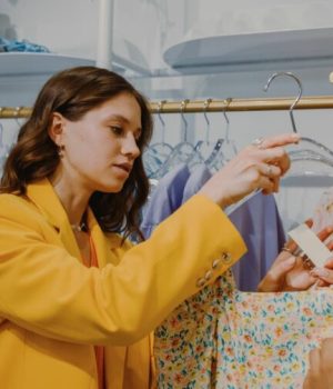 Une femme en train de regarder une étiquette de vêtement dans une boutique de mode