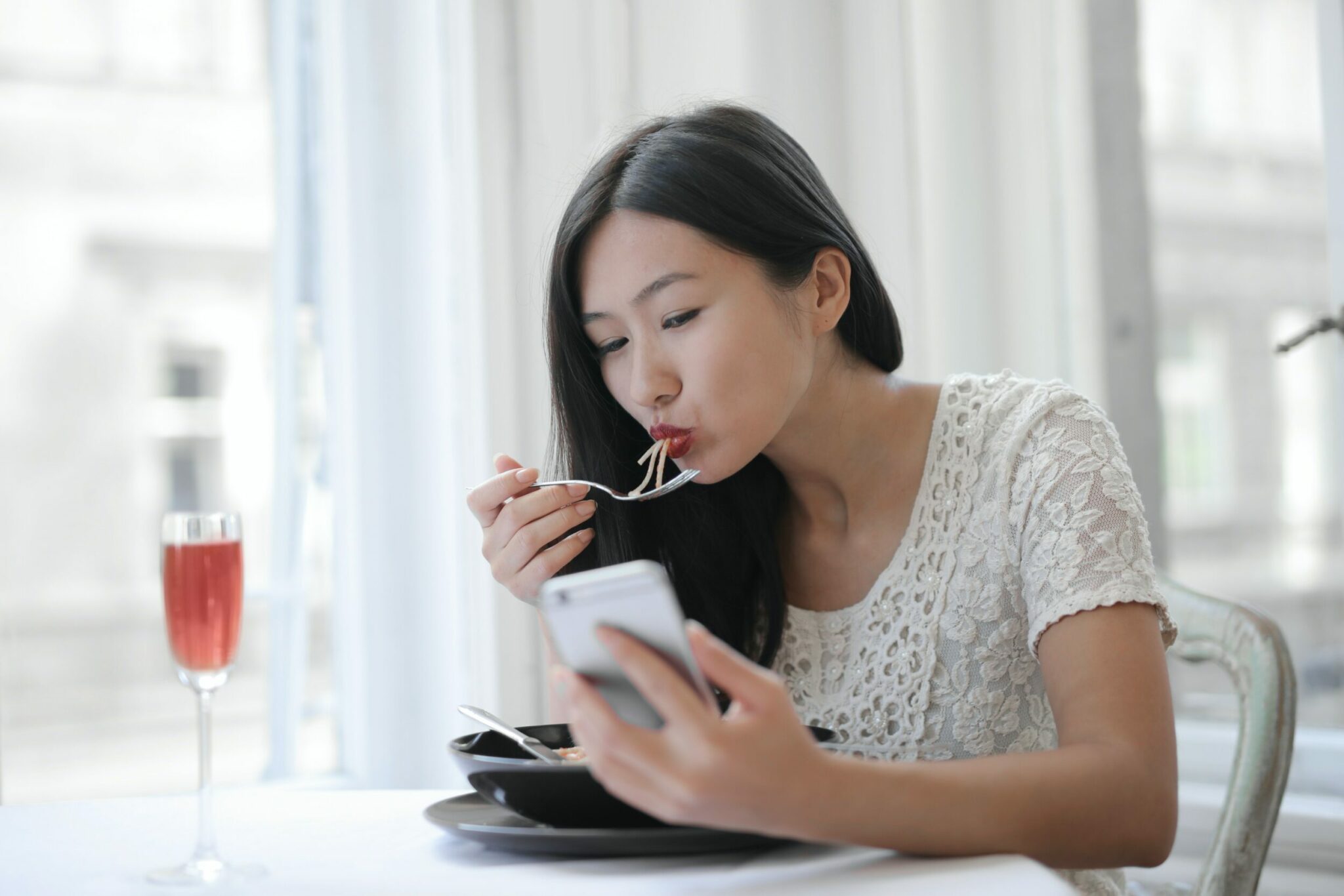 Femme recevant un sms pendant un repas Femme recevant un sms pendant un repas