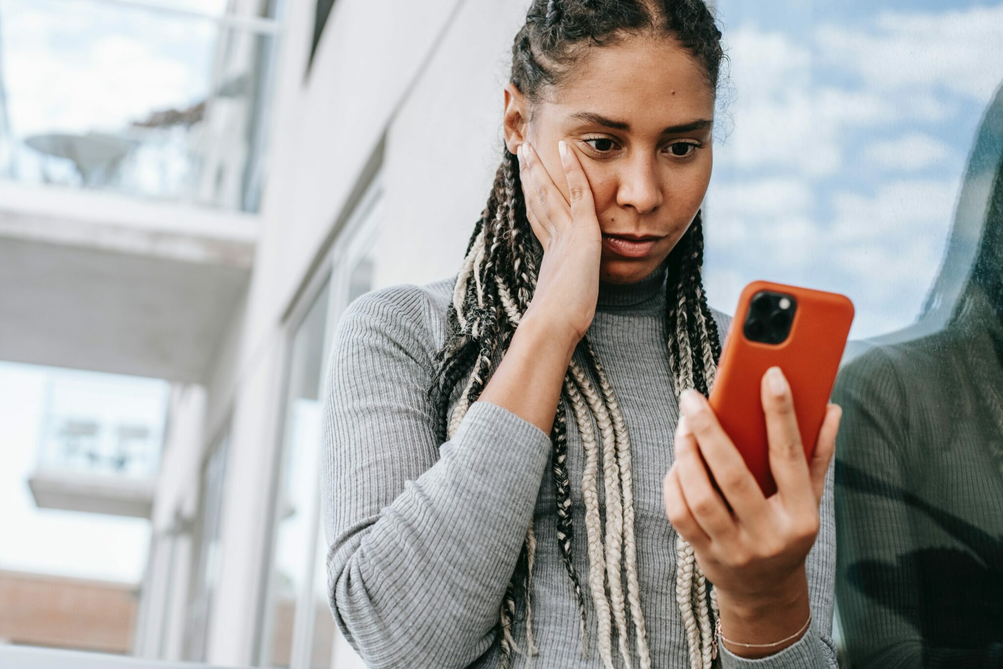 Jeune femme interloquée devant son smartphone Jeune femme interloquée devant son smartphone